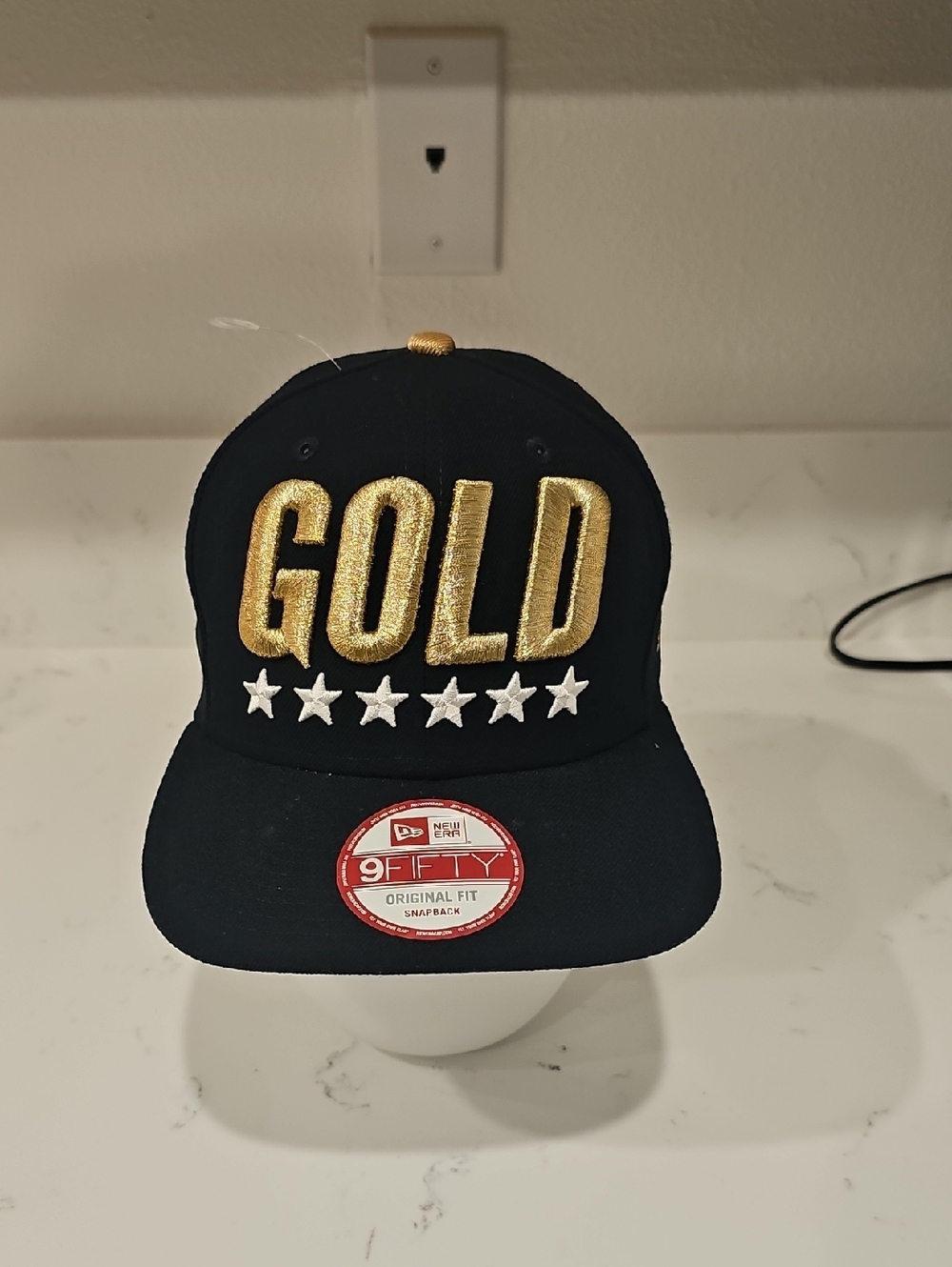 New Era Black Snapback Hat with Gold 'GOLD' Embroidery